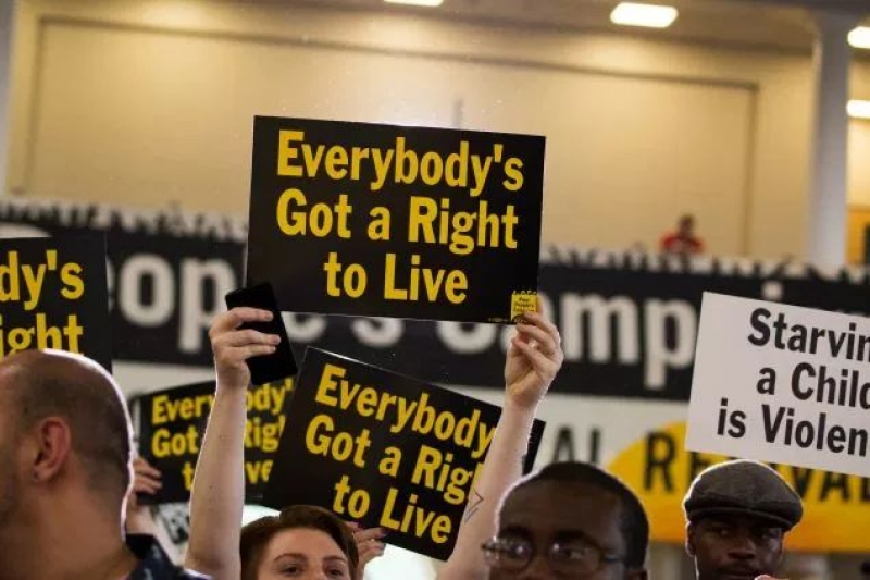 Attendees hold signs at the Poor People&rsquo;s Moral Action Congress at Trinity University in Washington D.C. 